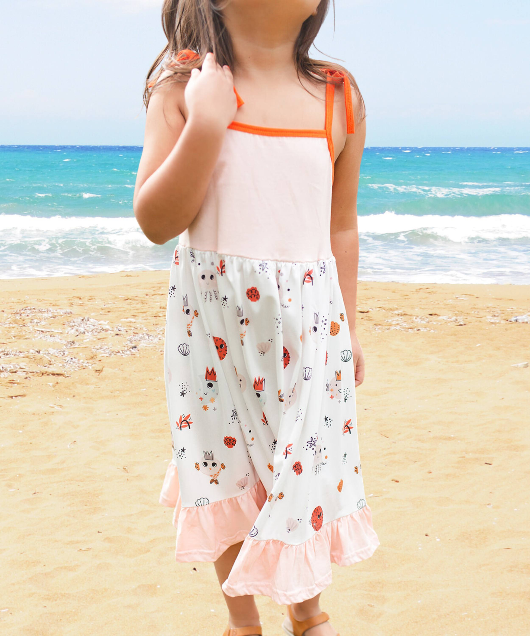Vestido de verano para playa color rosa suave con capas de volantes en la falda y detalles de criaturas marinas en naranja y marrón
