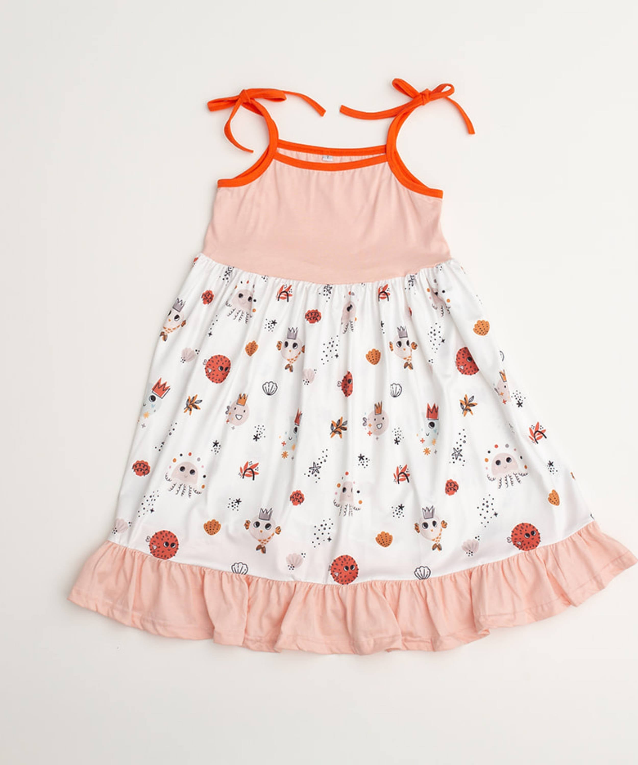 Vestido de verano para playa color rosa suave con capas de volantes en la falda y detalles de criaturas marinas en naranja y marrón