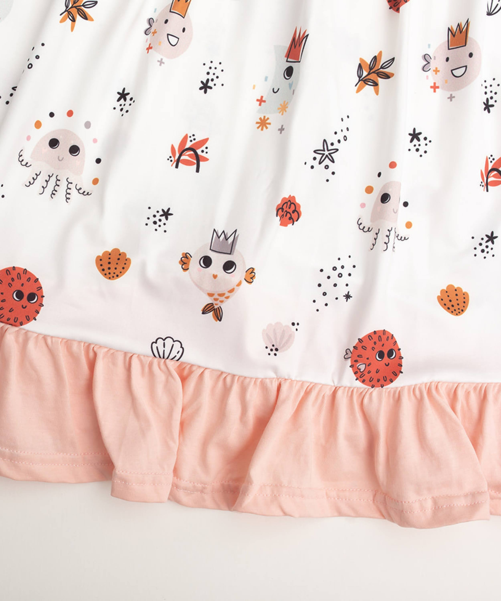 Vestido de verano para playa color rosa suave con capas de volantes en la falda y detalles de criaturas marinas en naranja y marrón